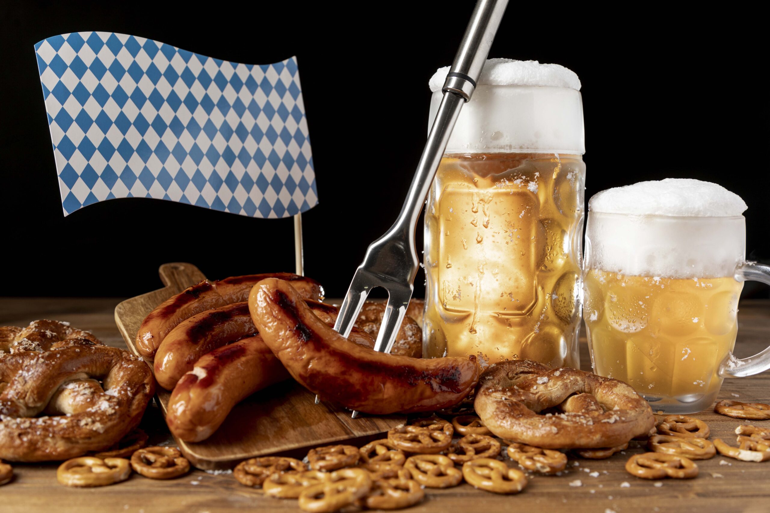 Dos jarras de cerveza con unas salchichas