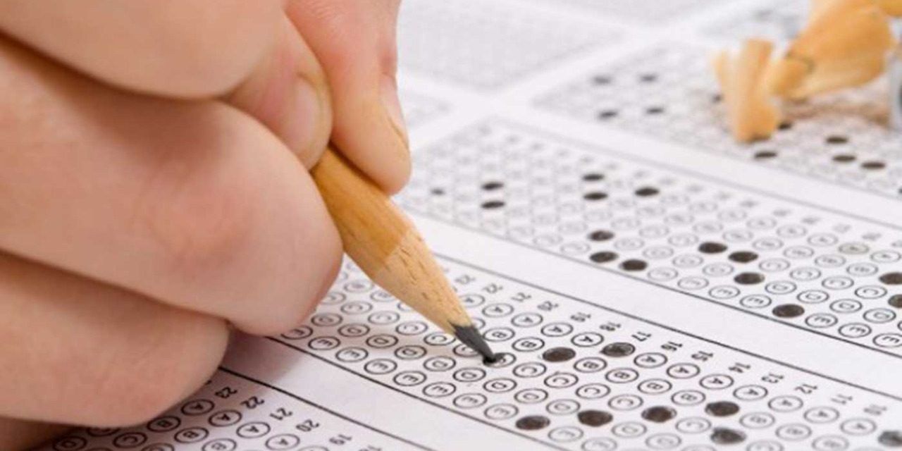 Mano sosteniendo un lápiz, con el cual se responde un examen ICFES