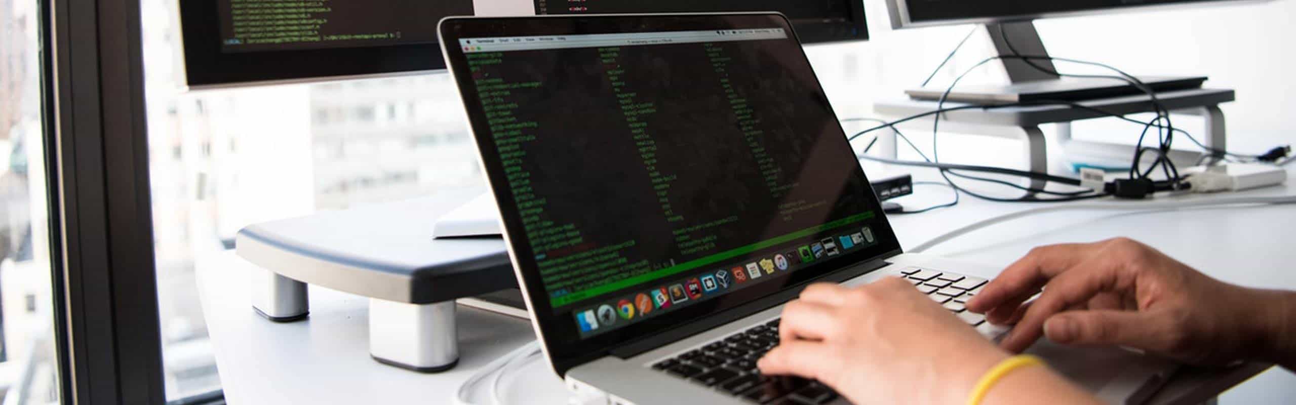 Manos de un programador tecleando en su laptop