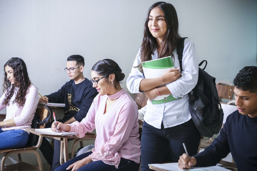 Estudiantes de Universidad en aula de clases, una estudiante de pie