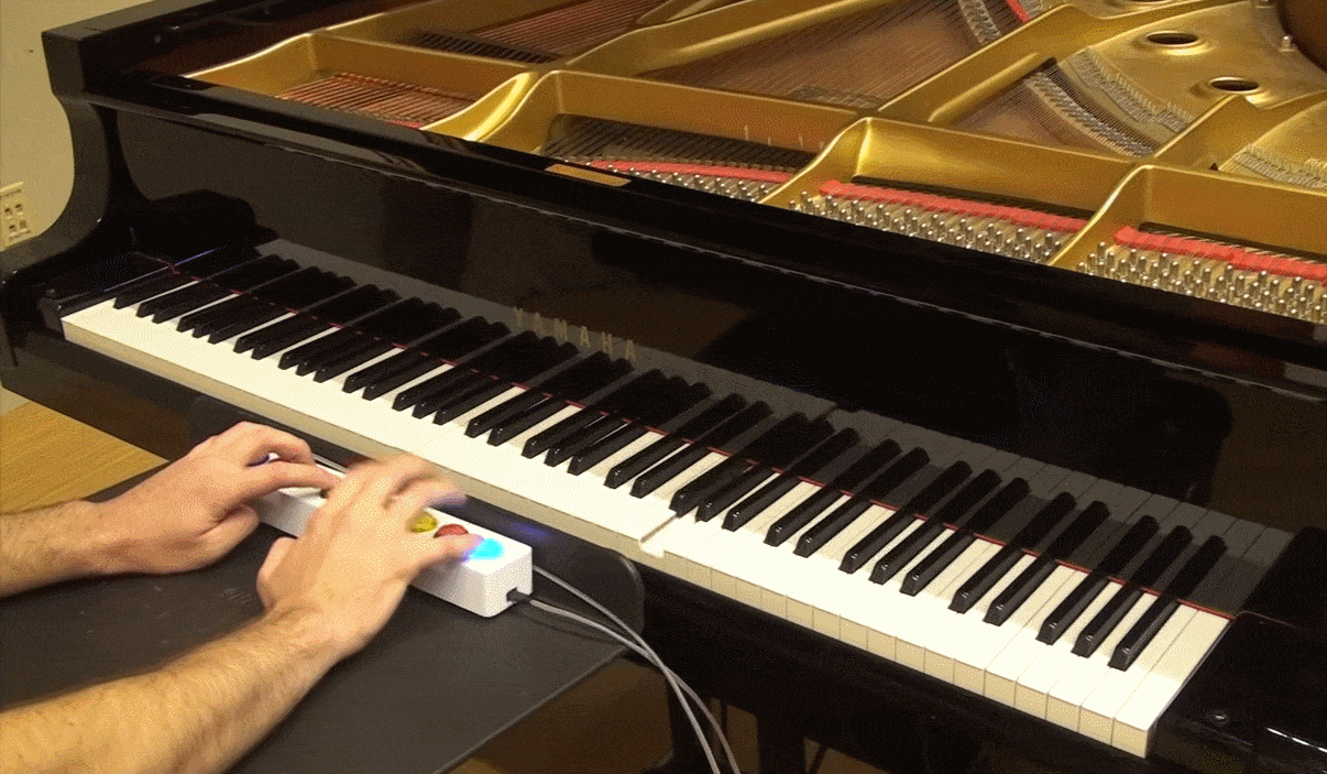 Manos oprimiendo botones que controlan las teclas de una piano.