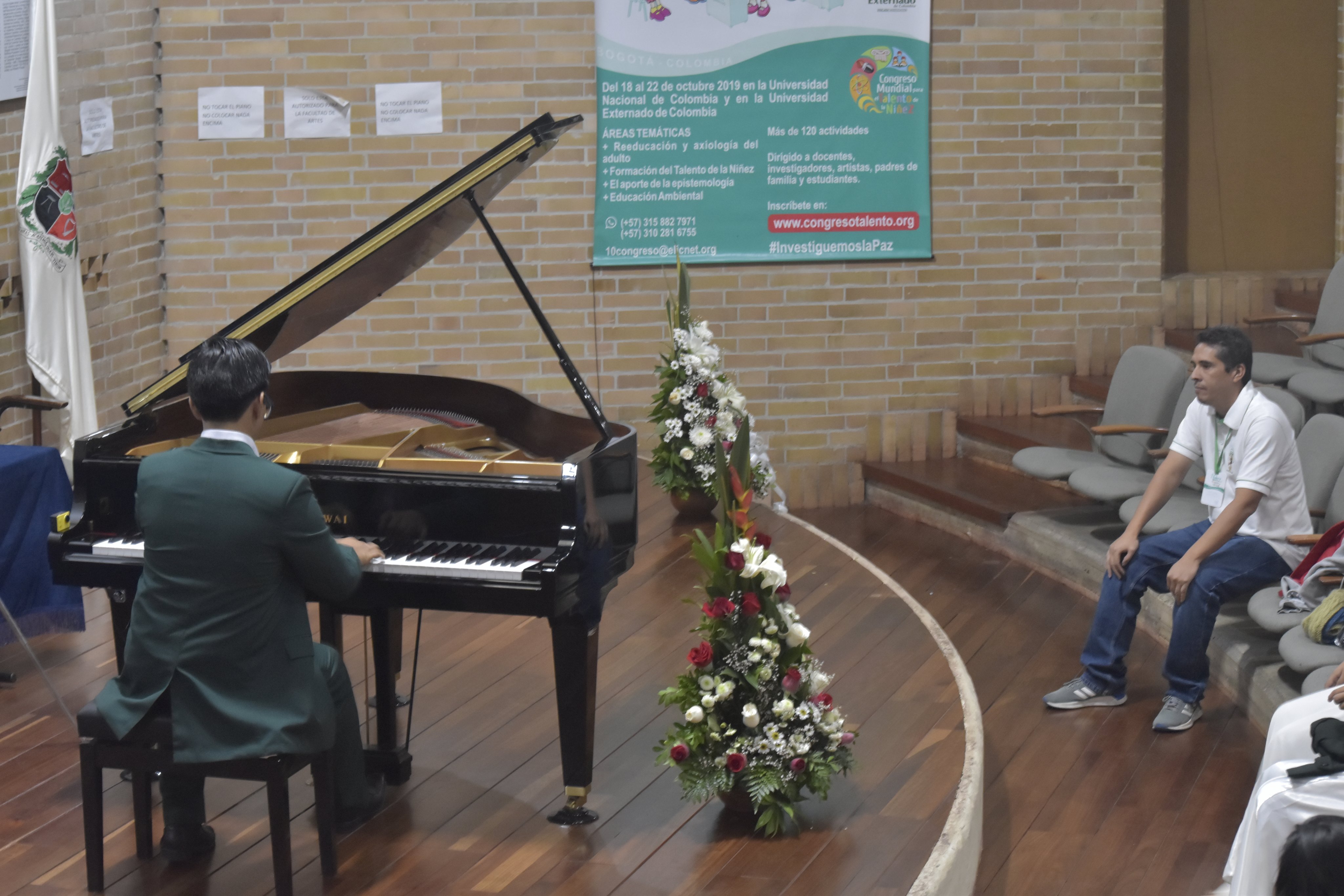 Pianista interpretando el piano frente a un espectador.