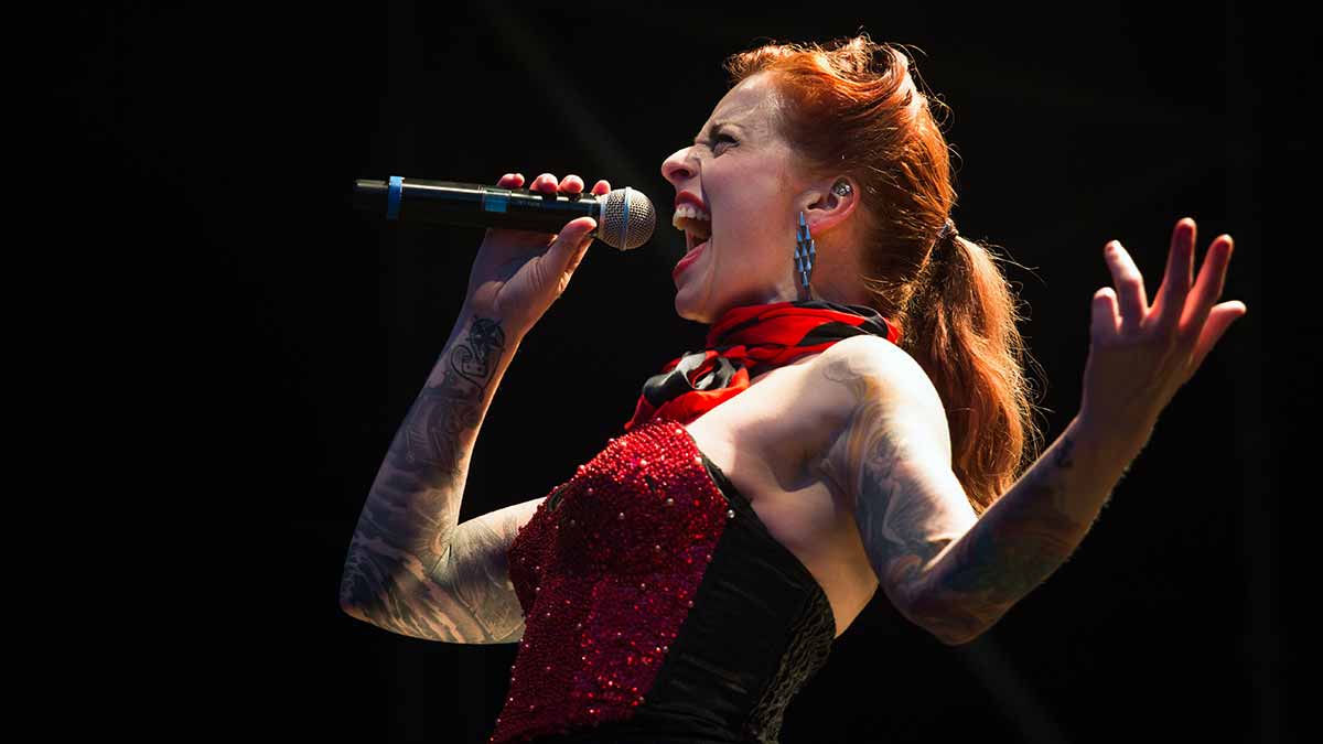 Chica con un vestido rojo cantando con tono fuerte