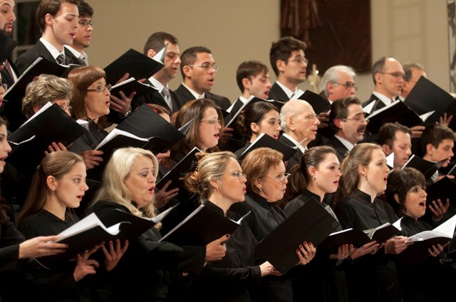 Grupo de personas cantando para un coro.