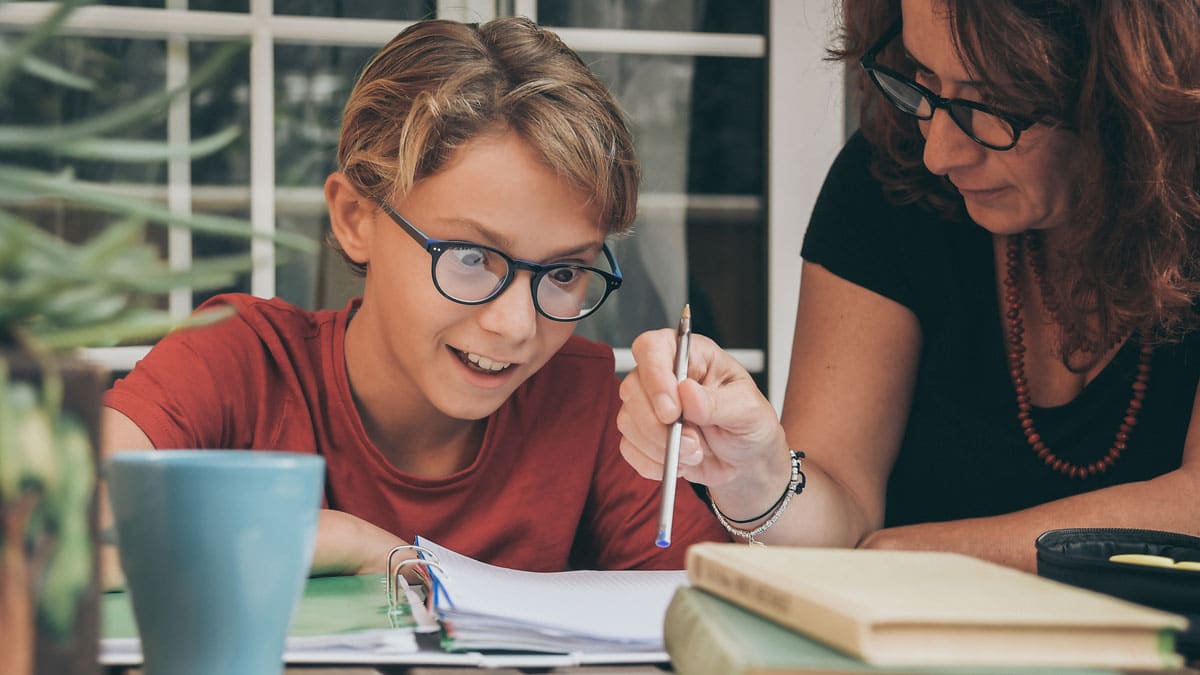 Chico estudiando junto a su profesora particular
