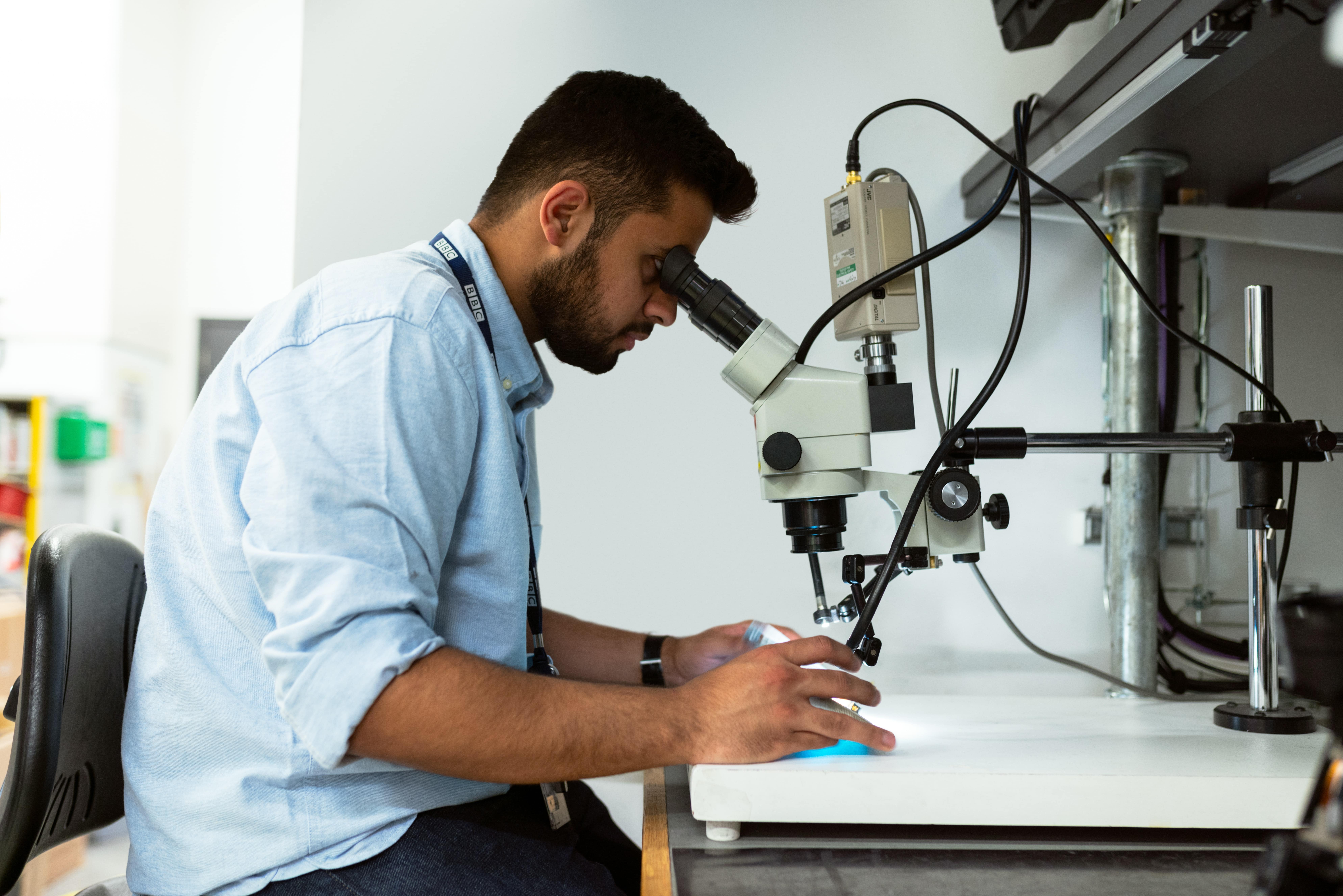 Hombre mirando por un microscopio