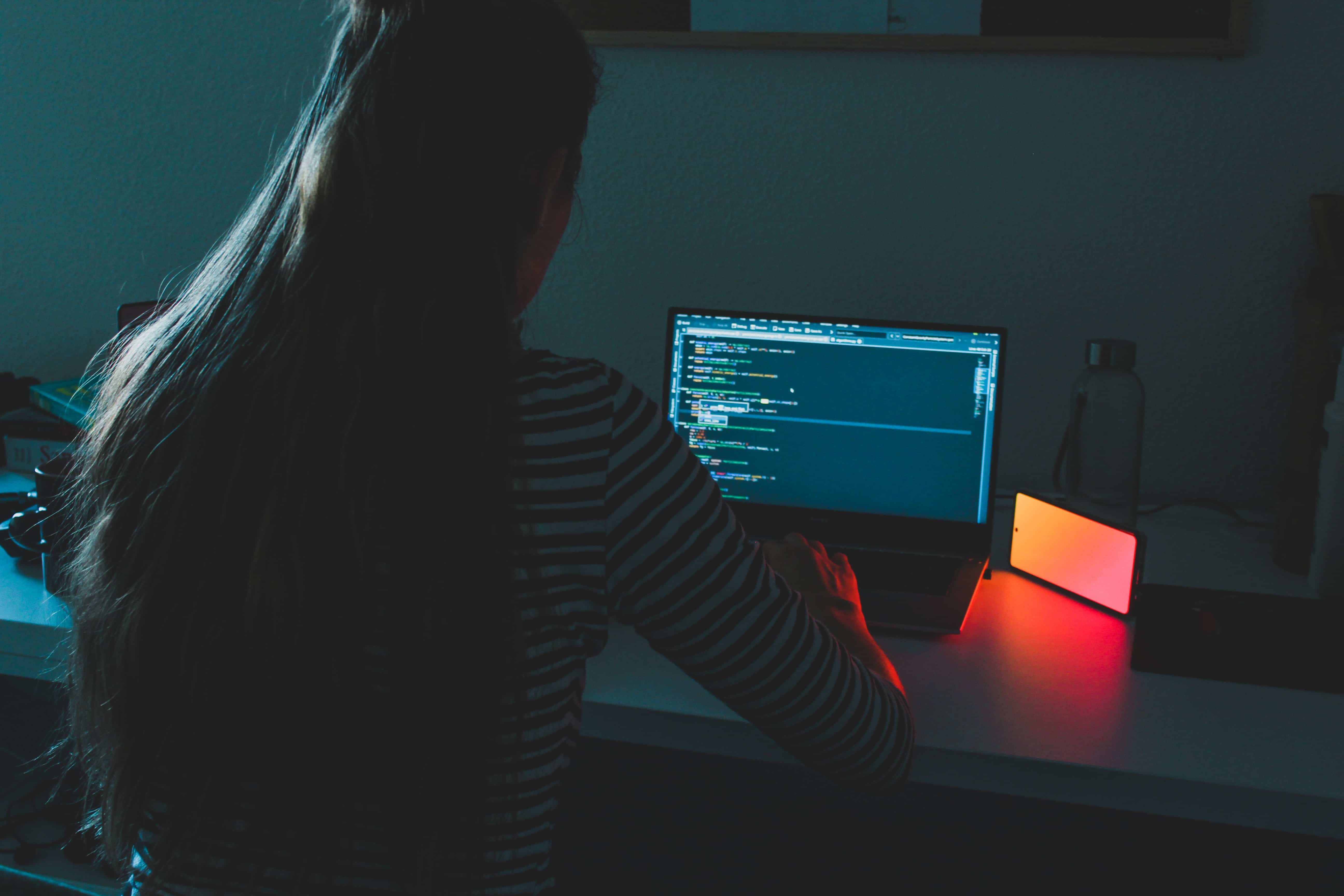 Mujer vista de espaldas trabajando en su laptop