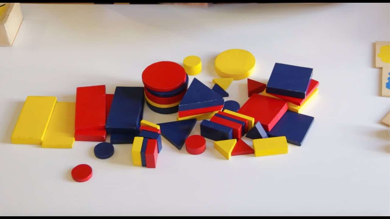 Fichas de tangram de colores, sobre una hoja blanca.