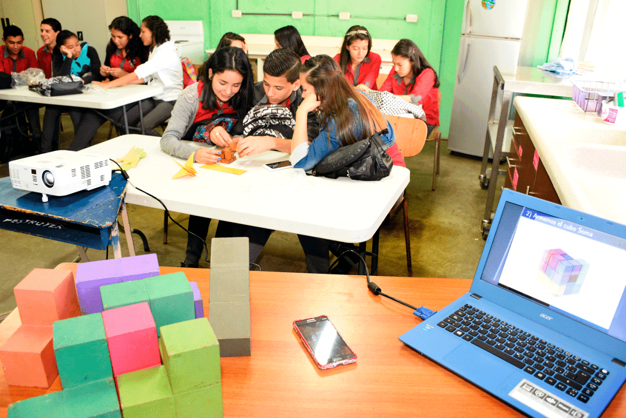Grupos de estudiantes dentro de una aula de clases.