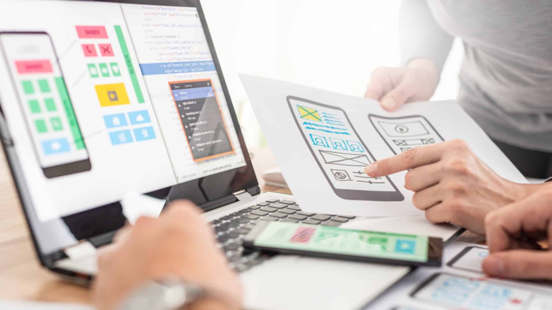 Manos de diseñadores, revisando diseños UX.