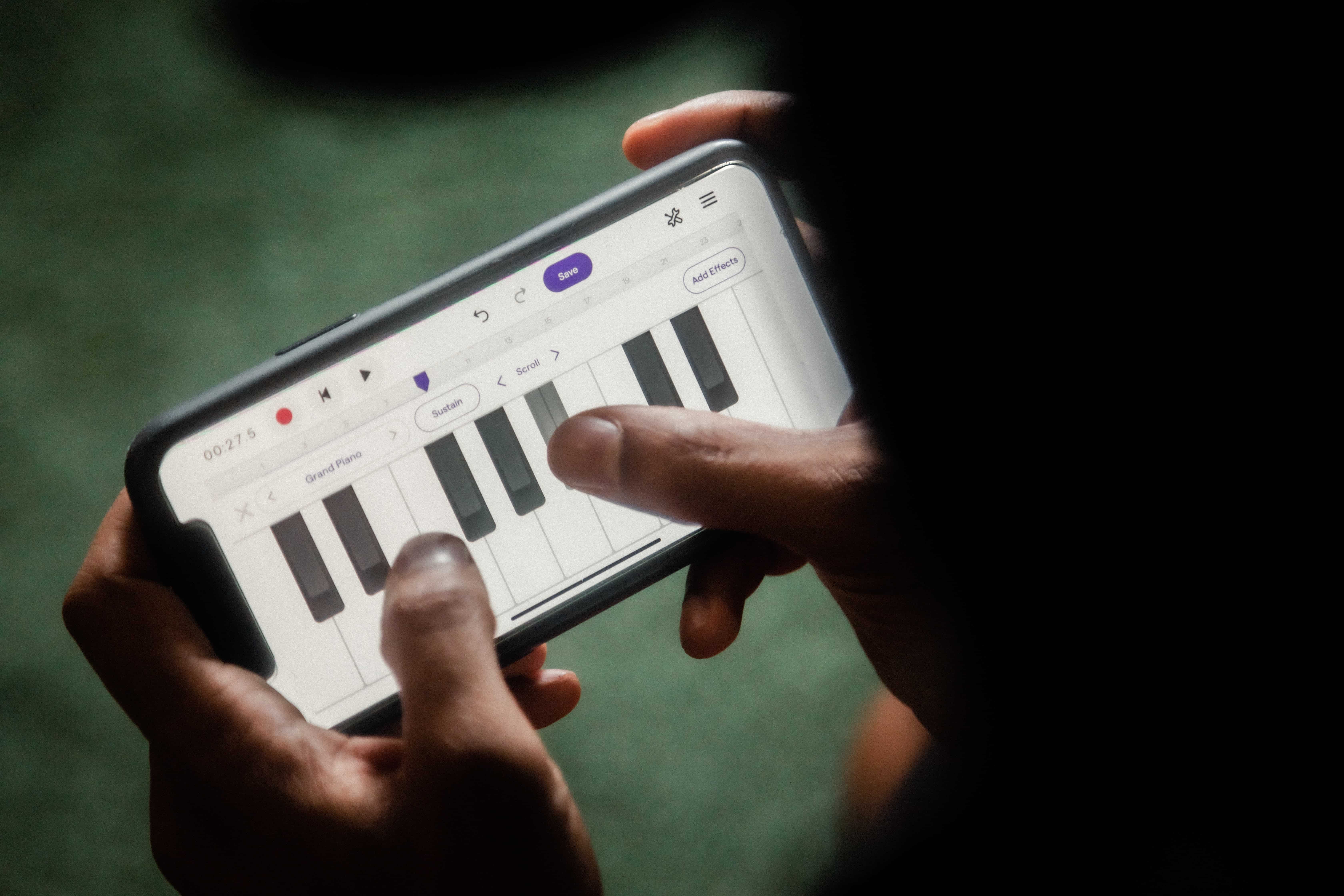 Persona usando una aplicación de piano en su celular