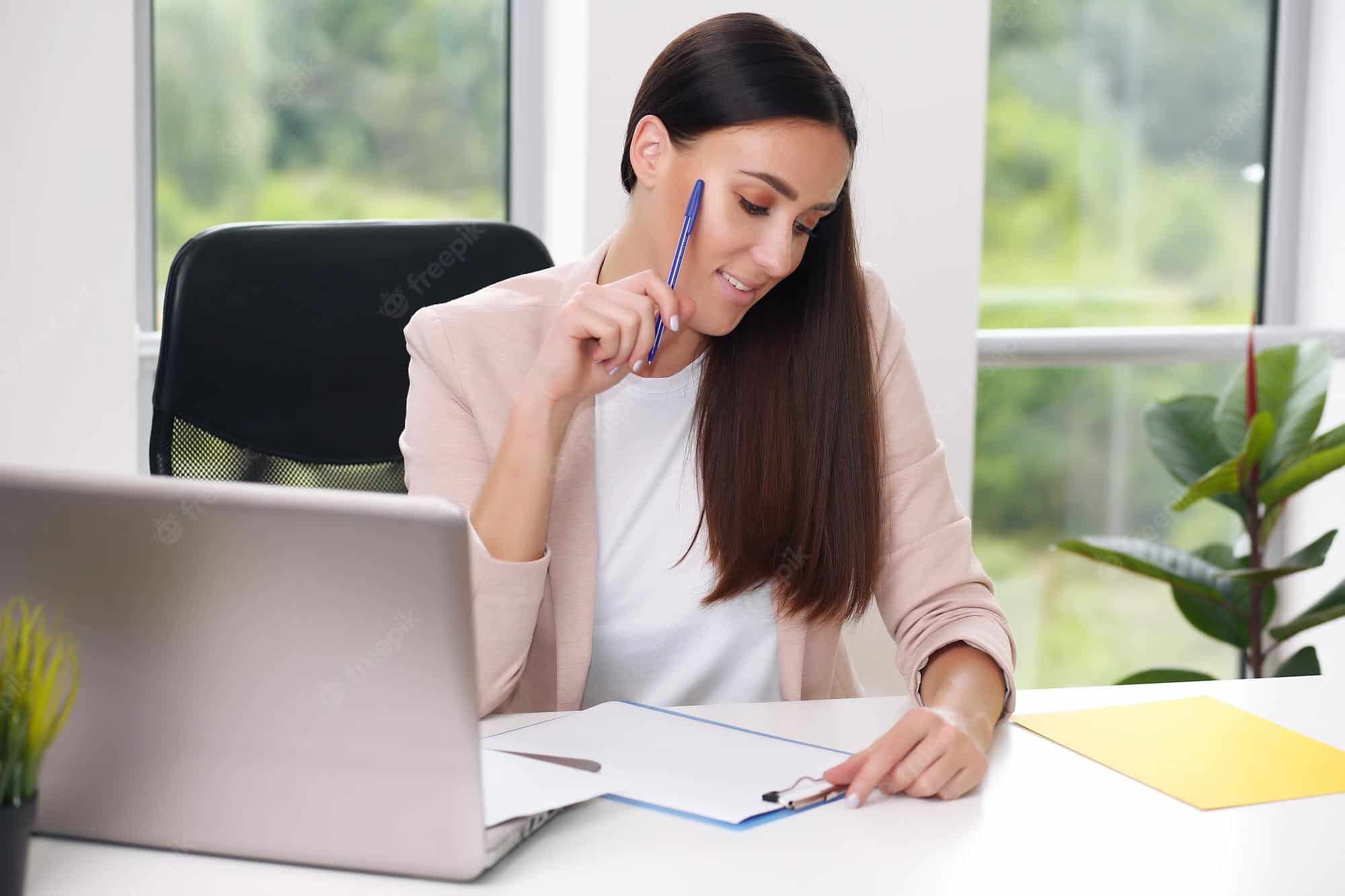 Chica viendo sus notas, mientras estudia programación online.