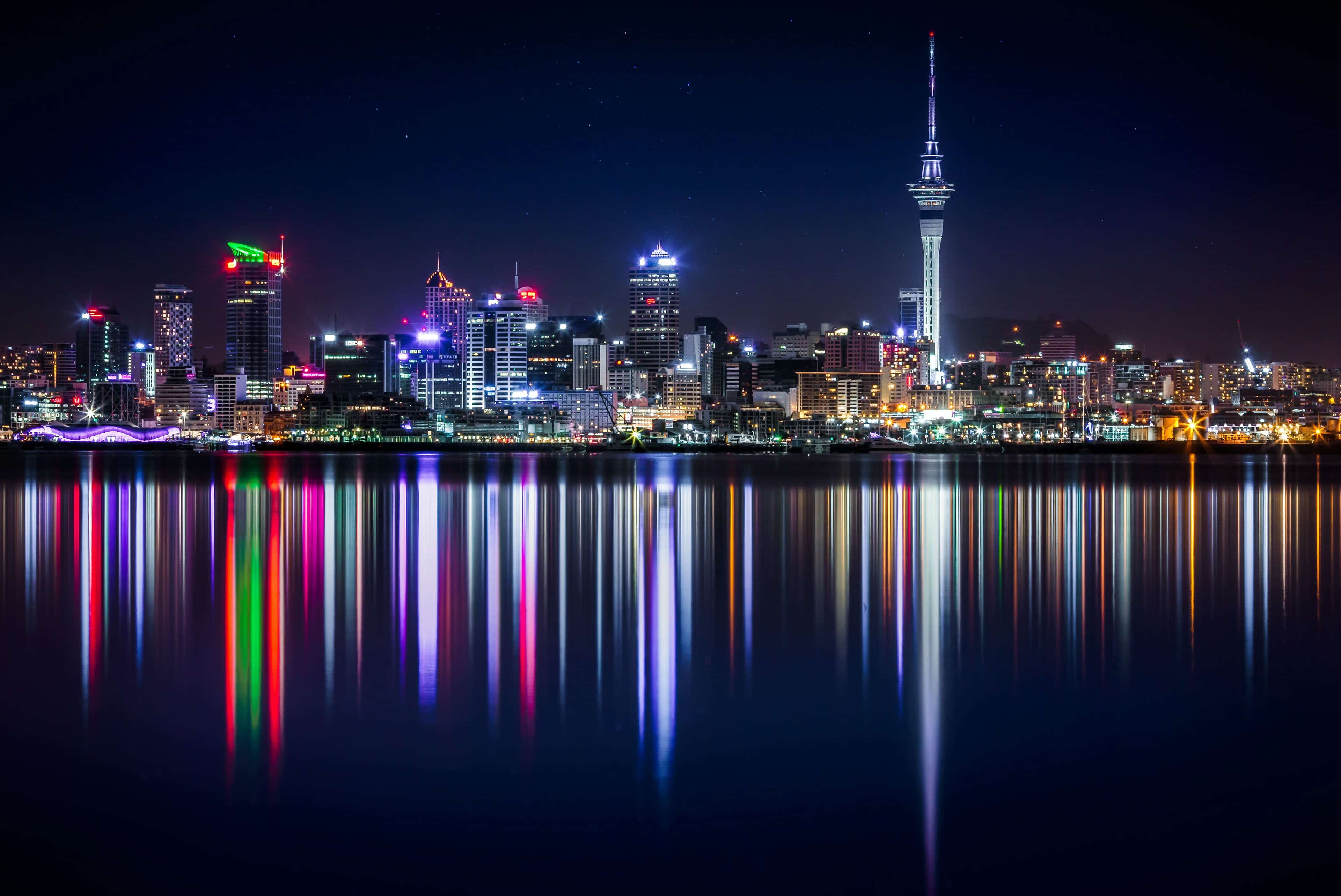 Auckland, New Zealand de noche, las luces de los edificios se reflejan en el rio