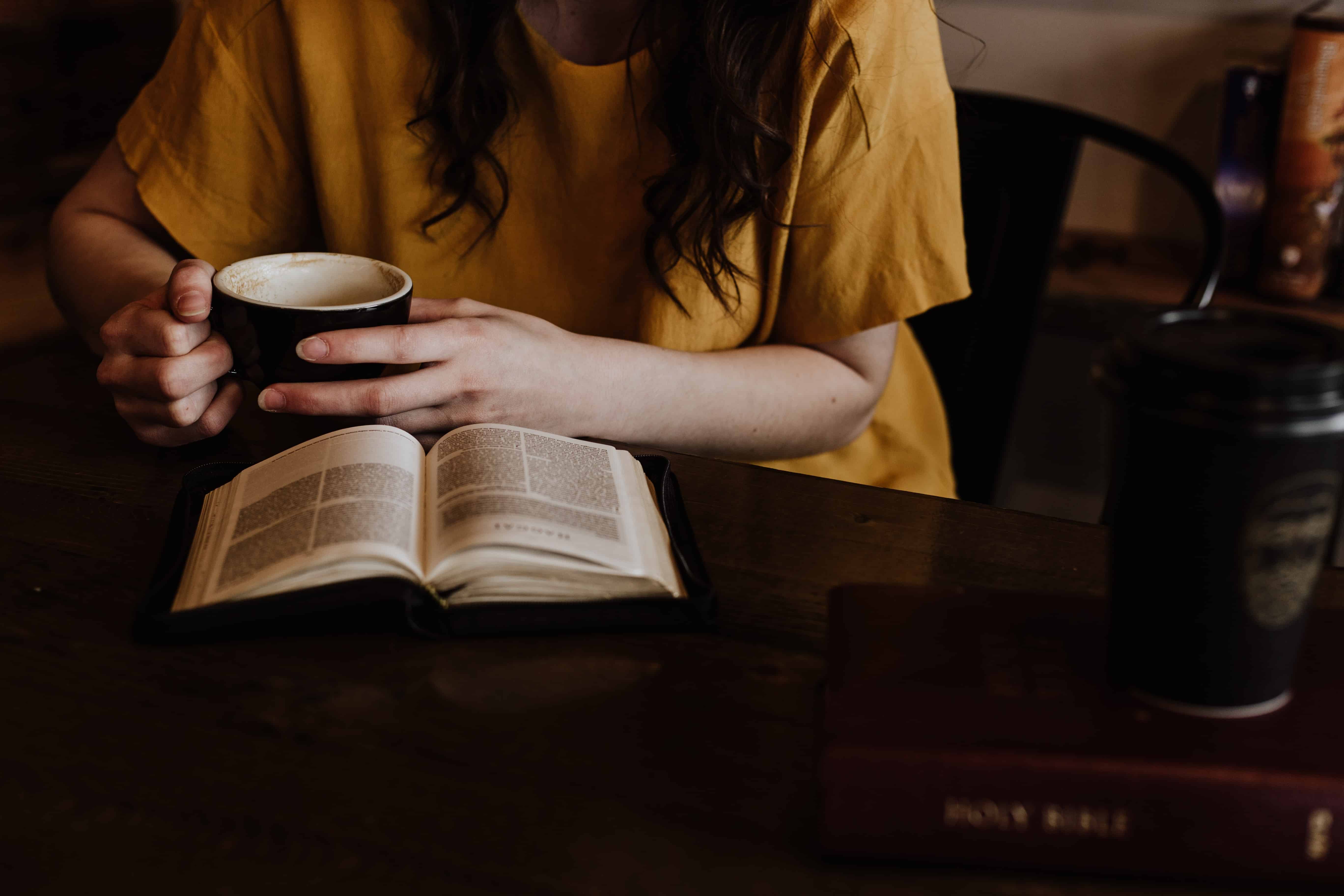 Mujer tomando café y leyendo biblia