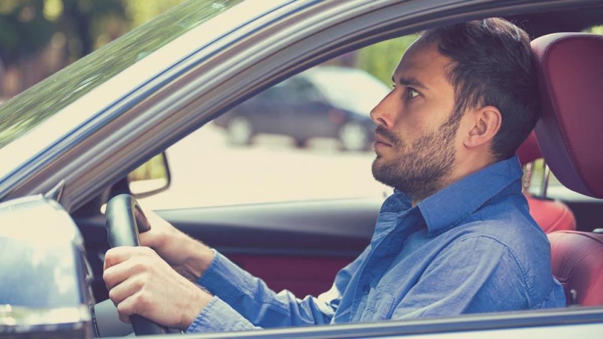 Chico sentado detrás del volante, sufriendo un ataque de Amaxofobia