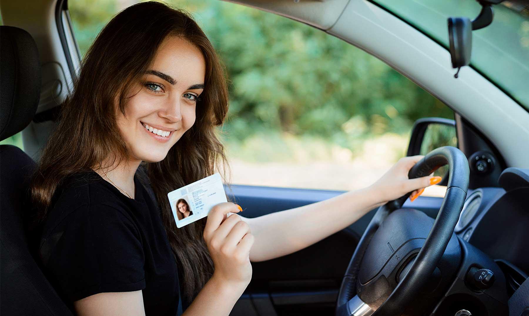 Chica sonriendo mientras enseña su licencia de conducir