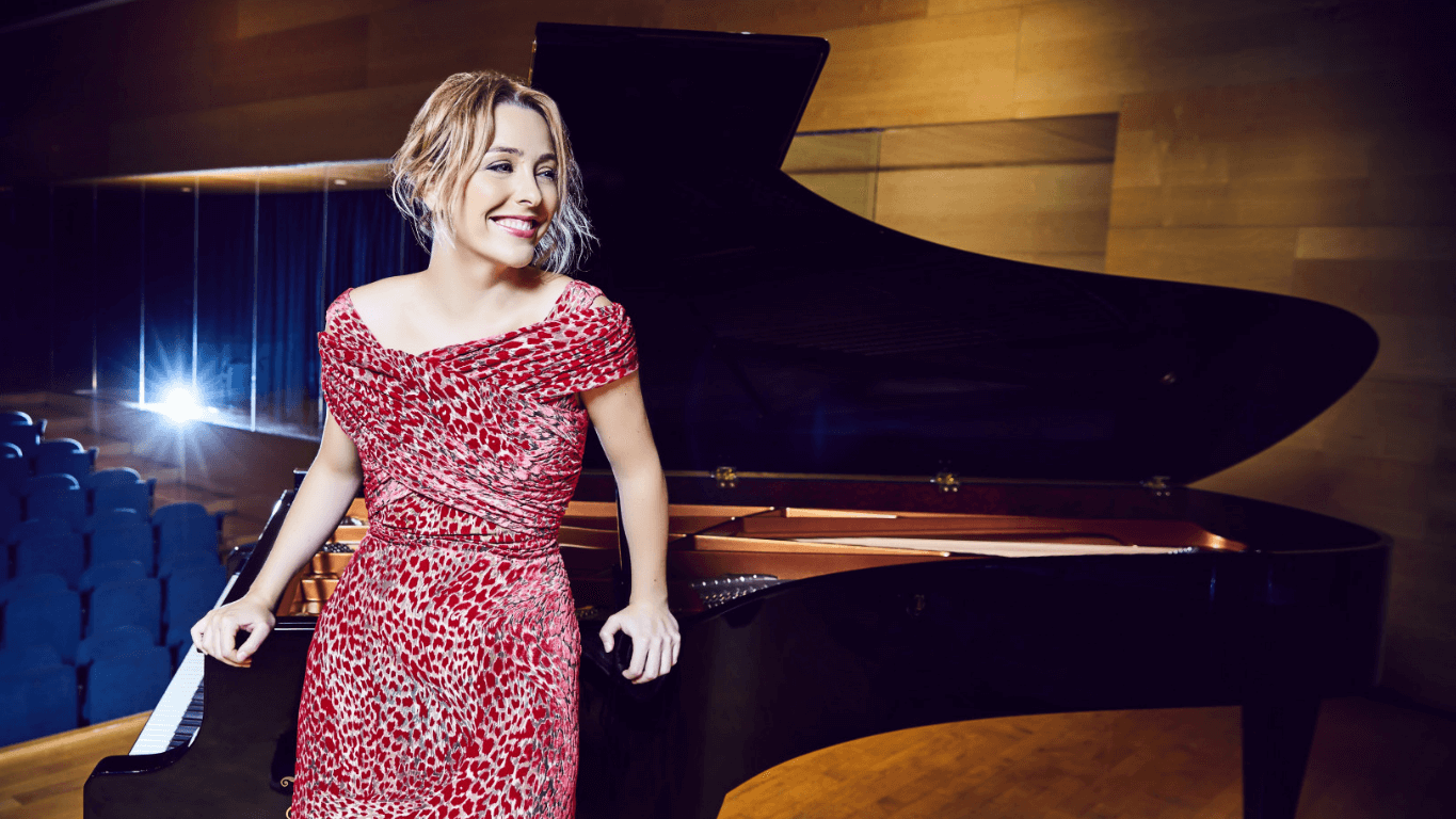 Chica sonriendo junto a un piano.