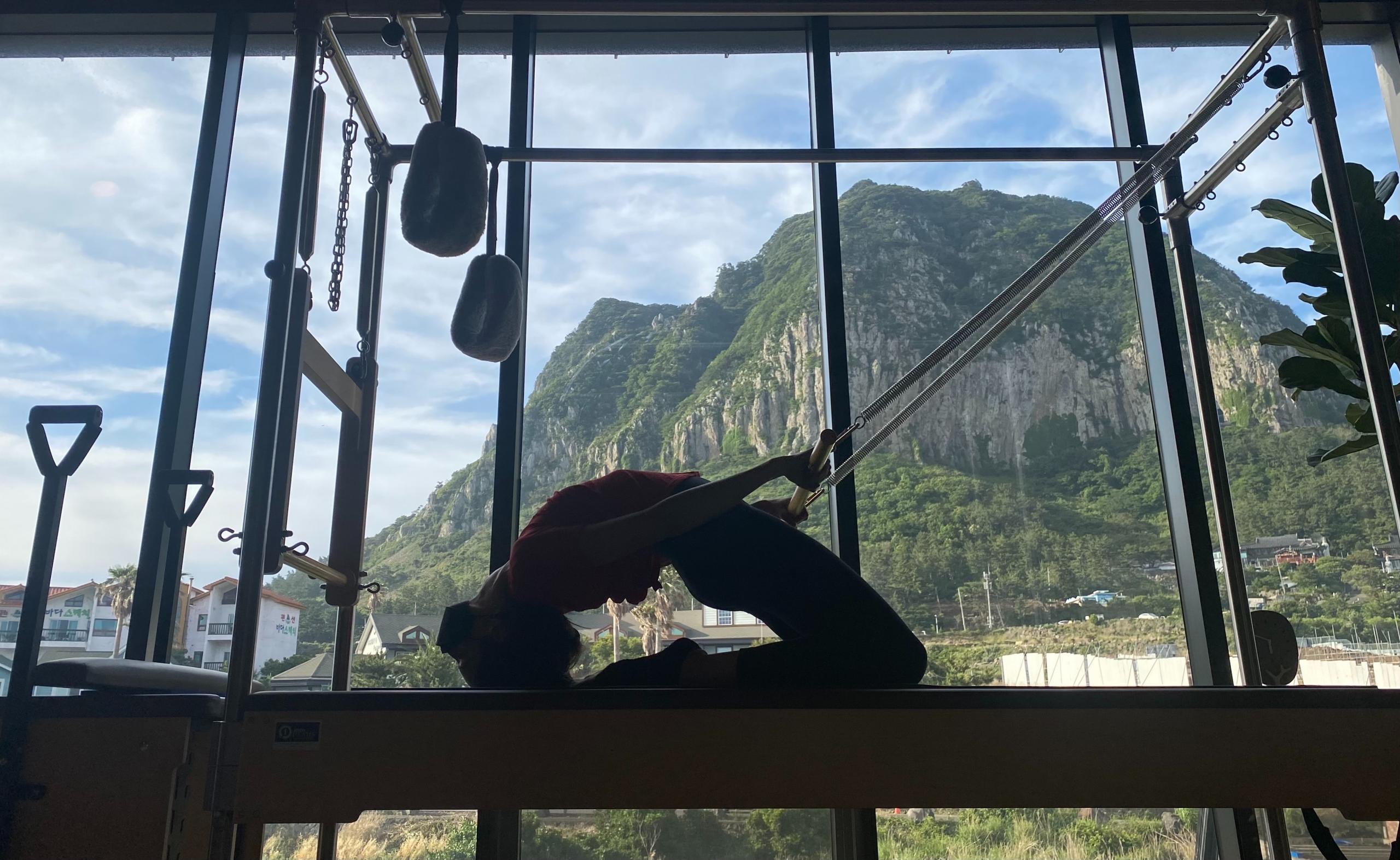 Chica realizando pilates, frente a una montaña. Foto de Ash Hayes