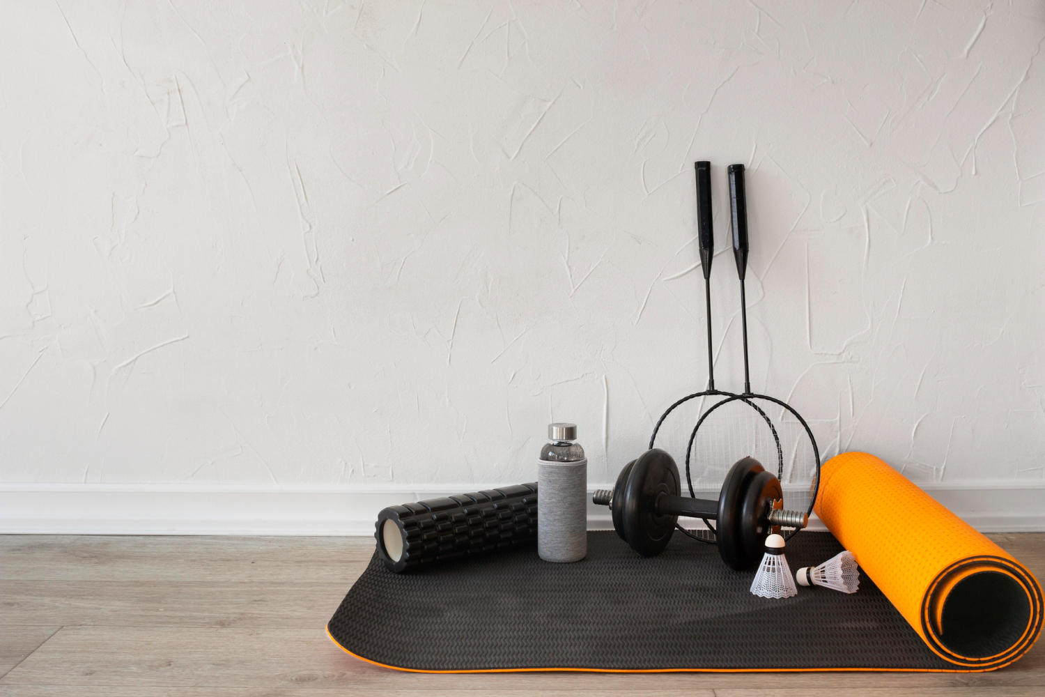 Equipos de practica de yoga apilados contra una pared blanca