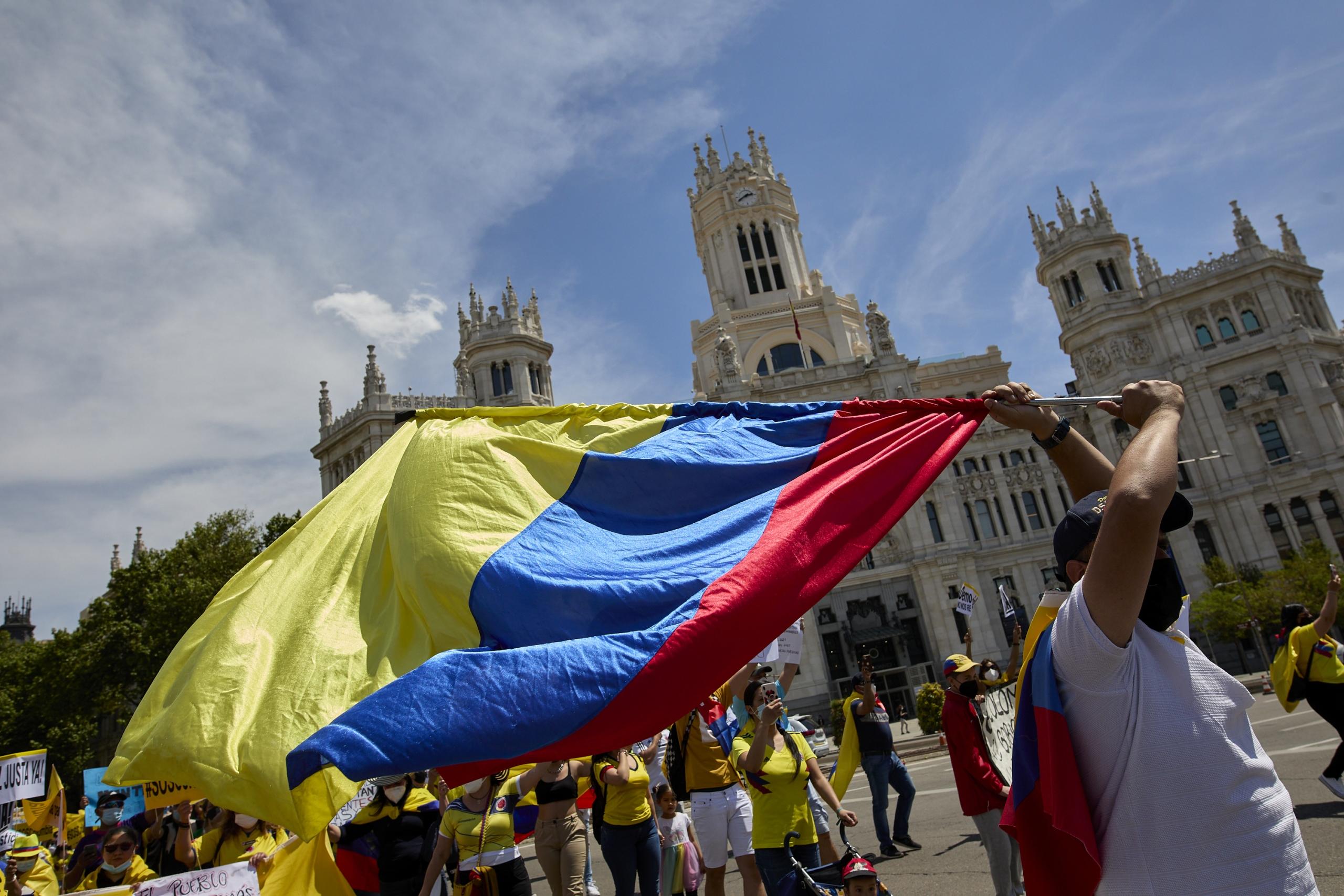 Mujer sosteniendo la bandera de Colombia mientras lidera una marcha