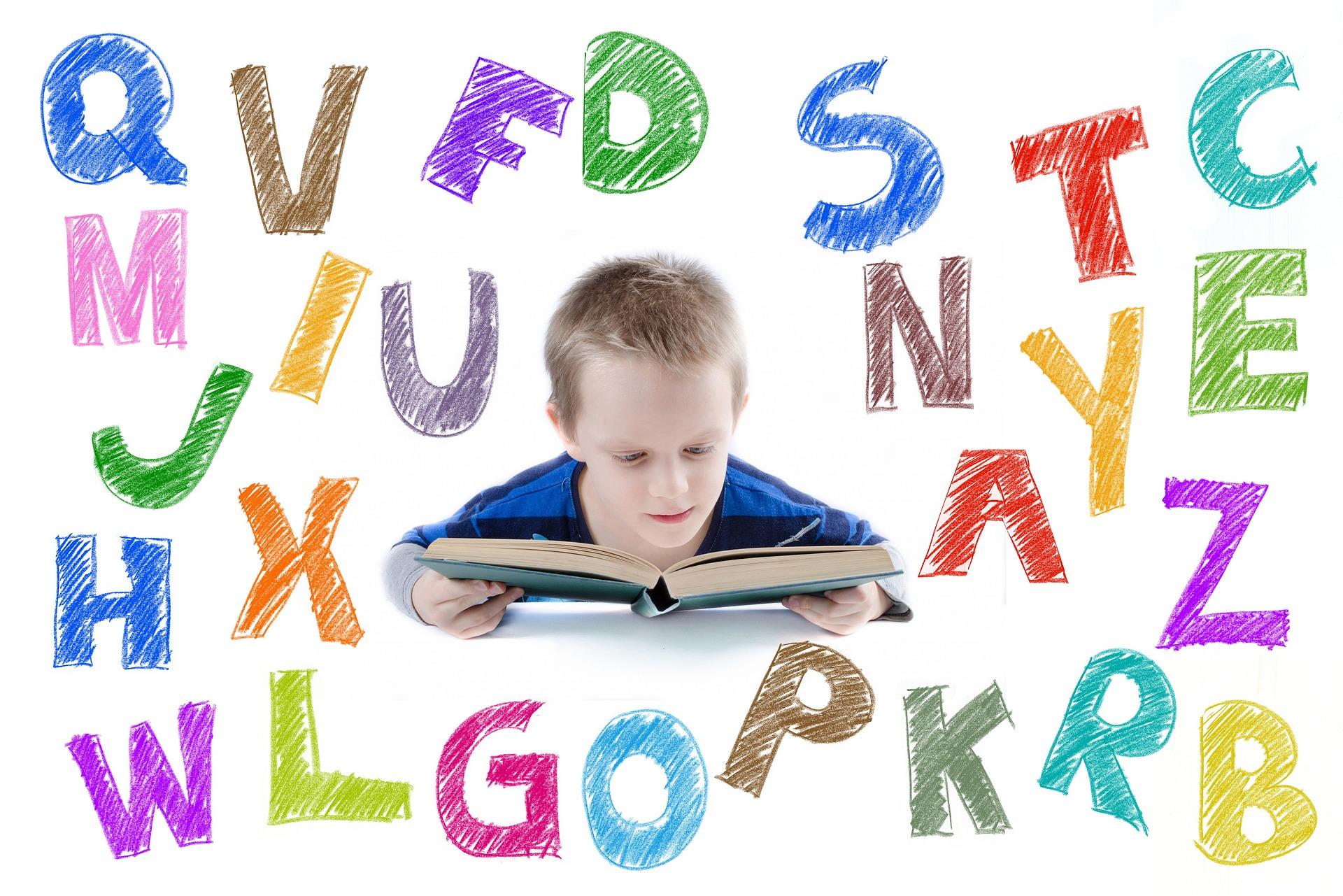 Letras hechas con colores y en el centro un niño con un libro
