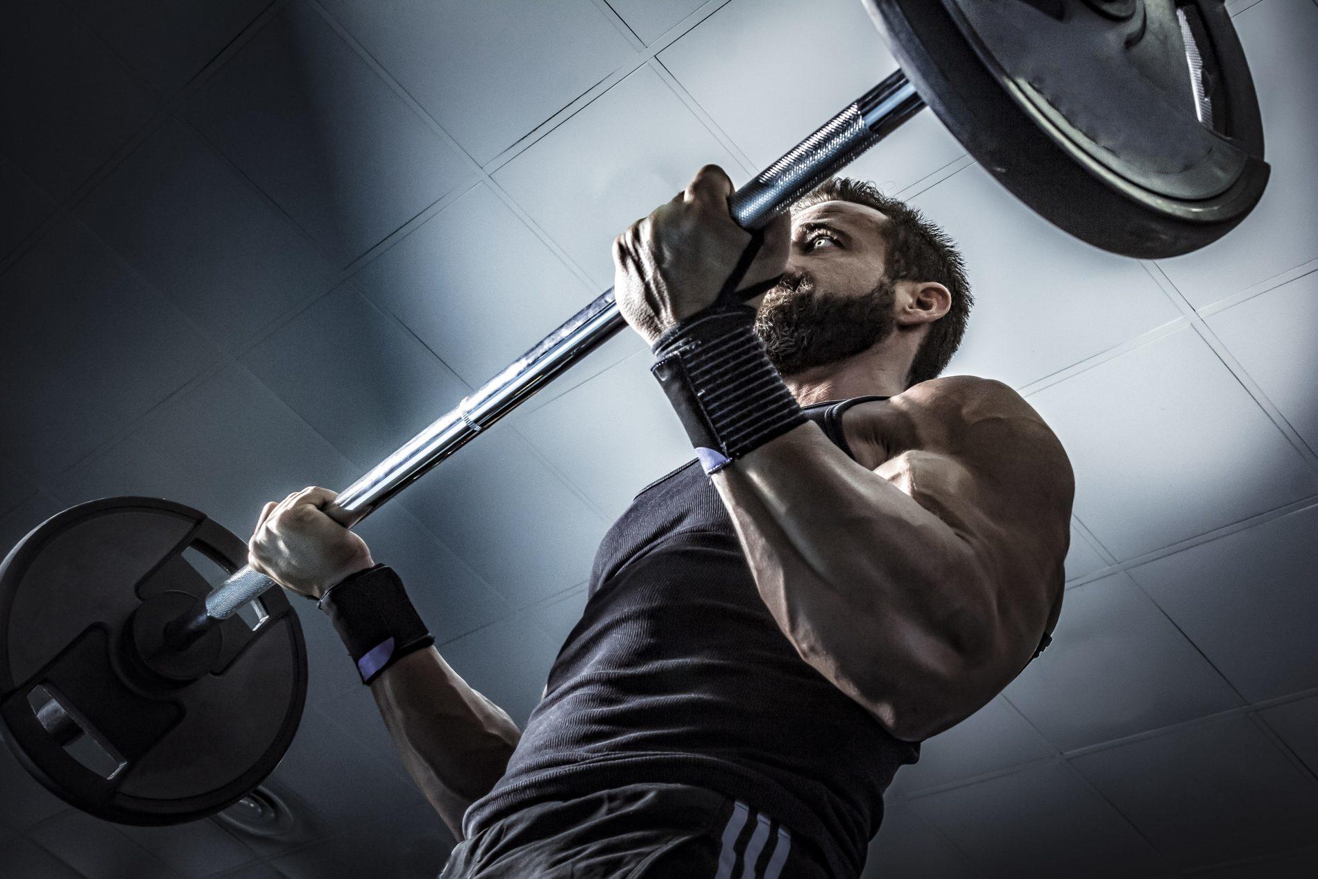 Hombre levantando una barra con discos