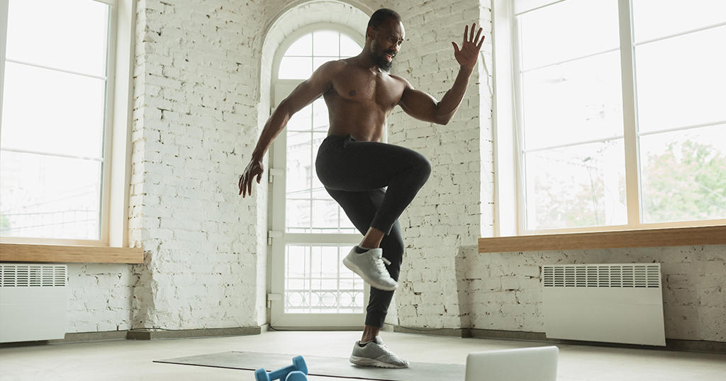 Chico realizando cardio en la sala de su casa 