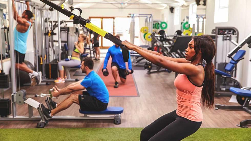 Grupo de personas realizando cada uno su rutina en un gym.