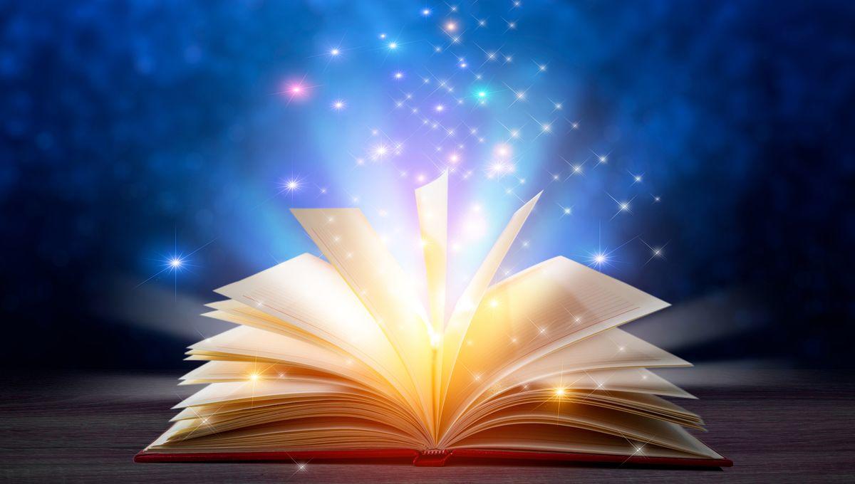 Libro abierto, mientras salen luces de su interior.