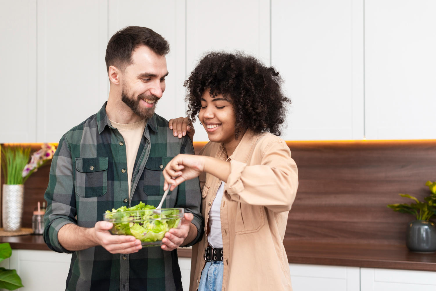 hombre y mujer hermosa tratando una ensalada sabrosa