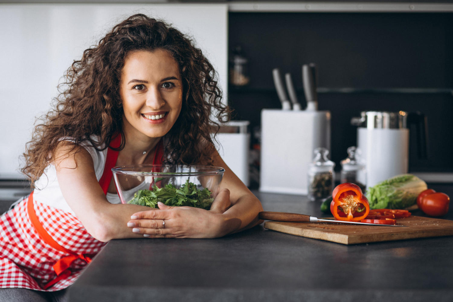 Mujer haciendo ensalada en la cocina