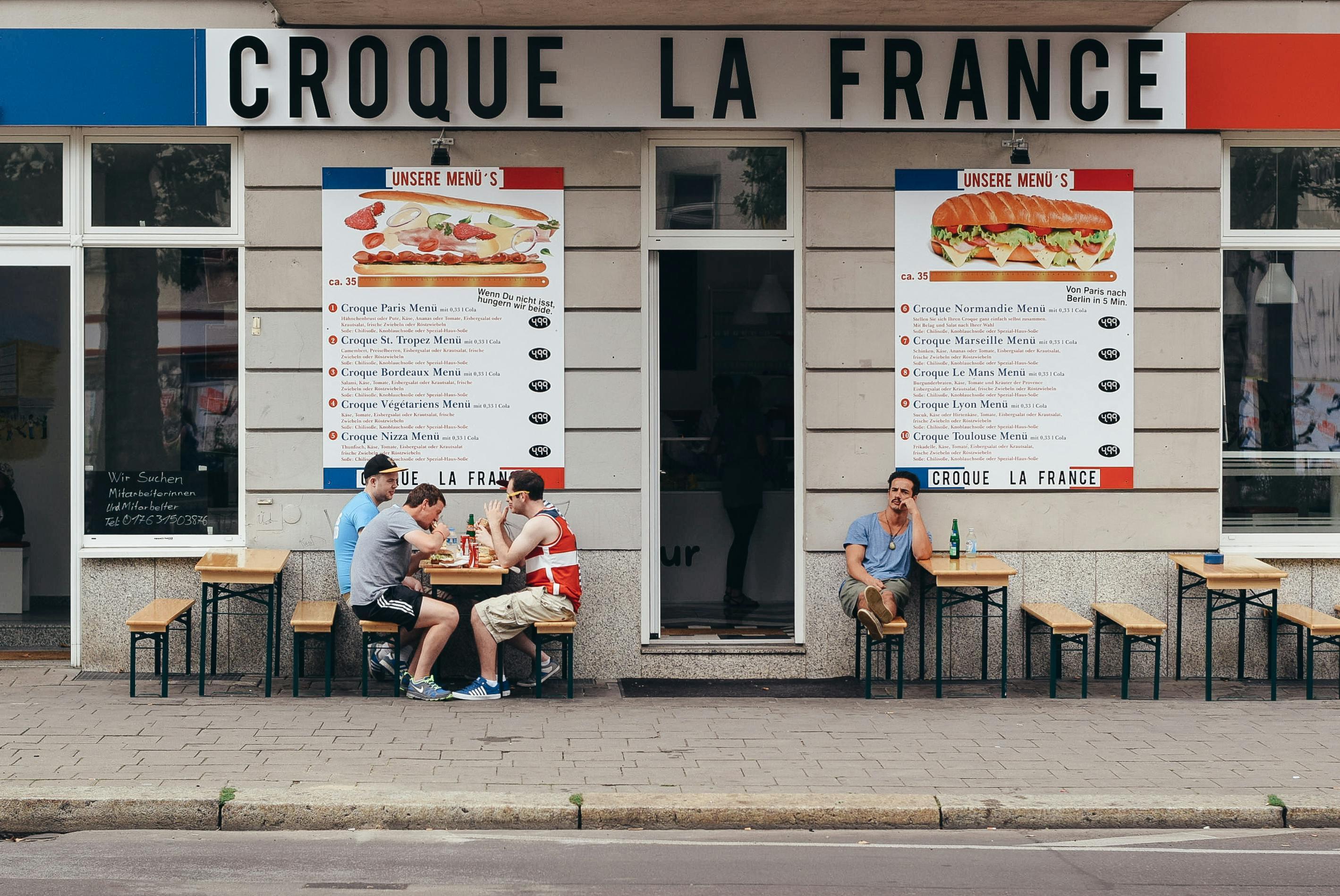 Imagen de personas comiendo afuera de un restaurante frances