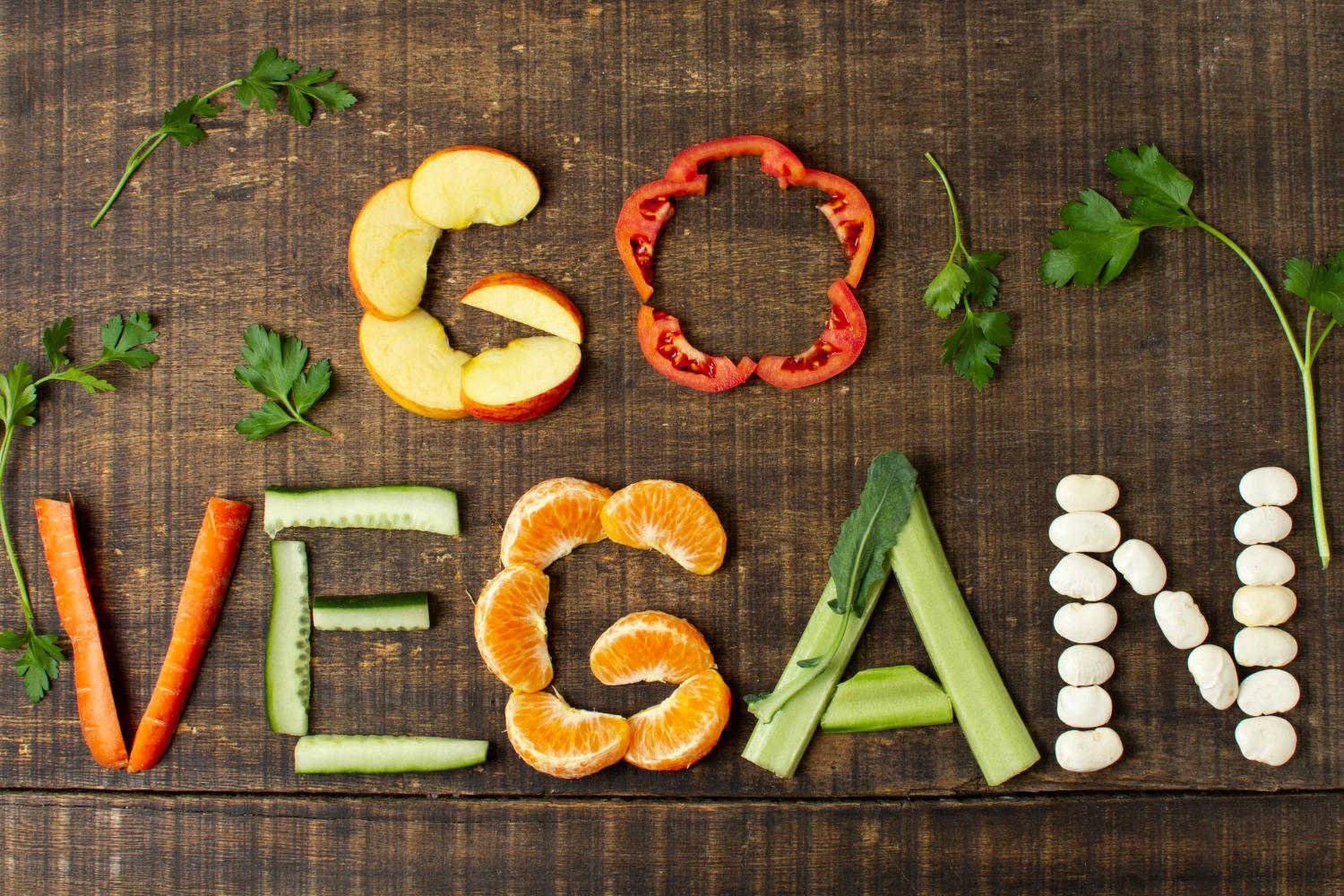 Letrero que dice "Go Vegan" escrito en frutas y vegetales