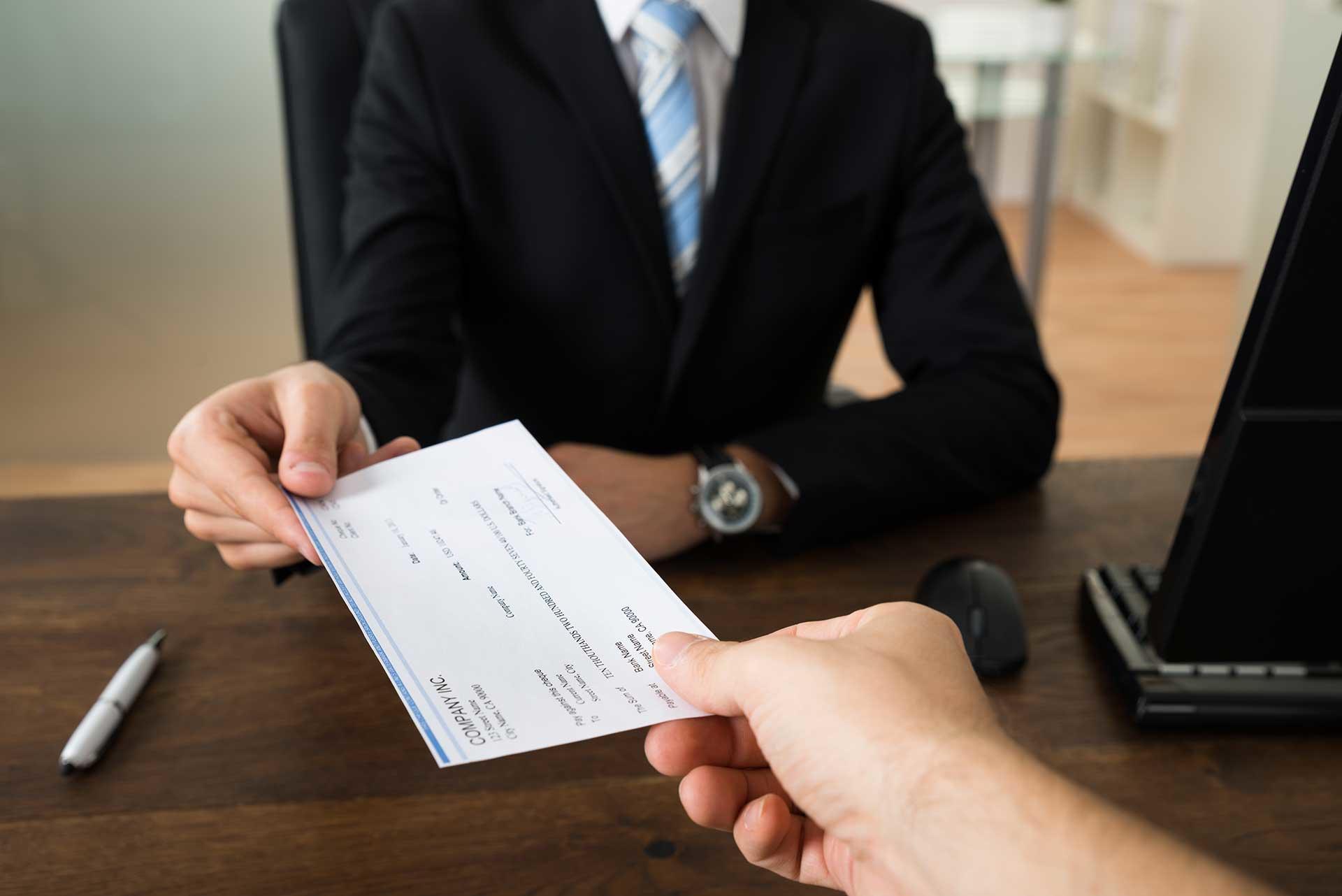 Empleador, entregando el desprendible de pago a su trabajador.