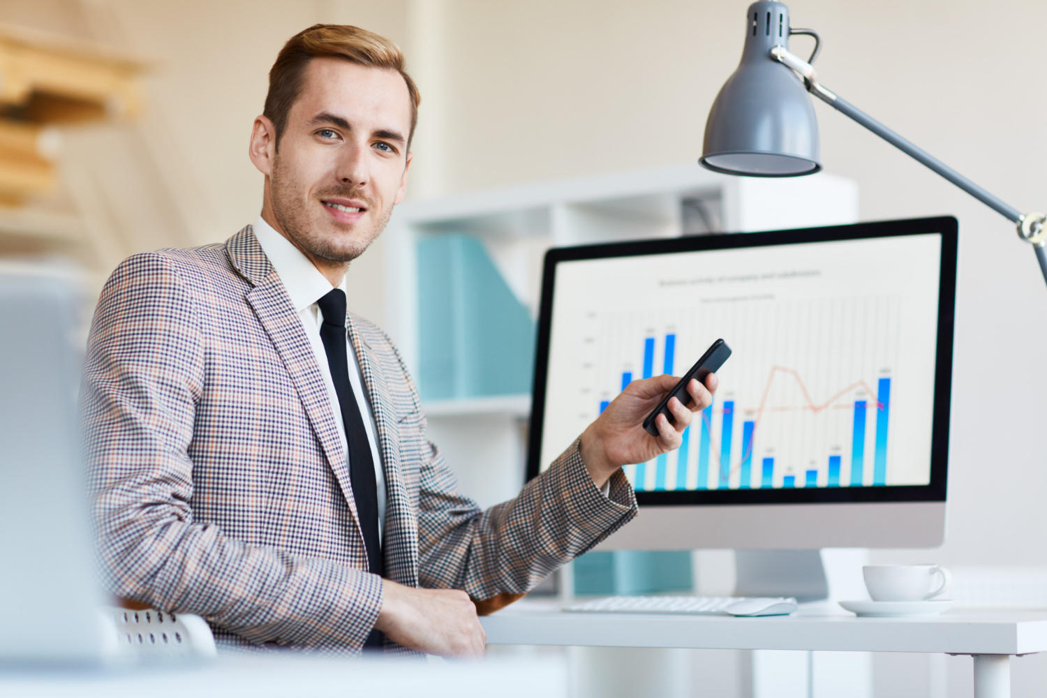 Hombre economista señalando una pantalla con gráfico de barras estadísticas