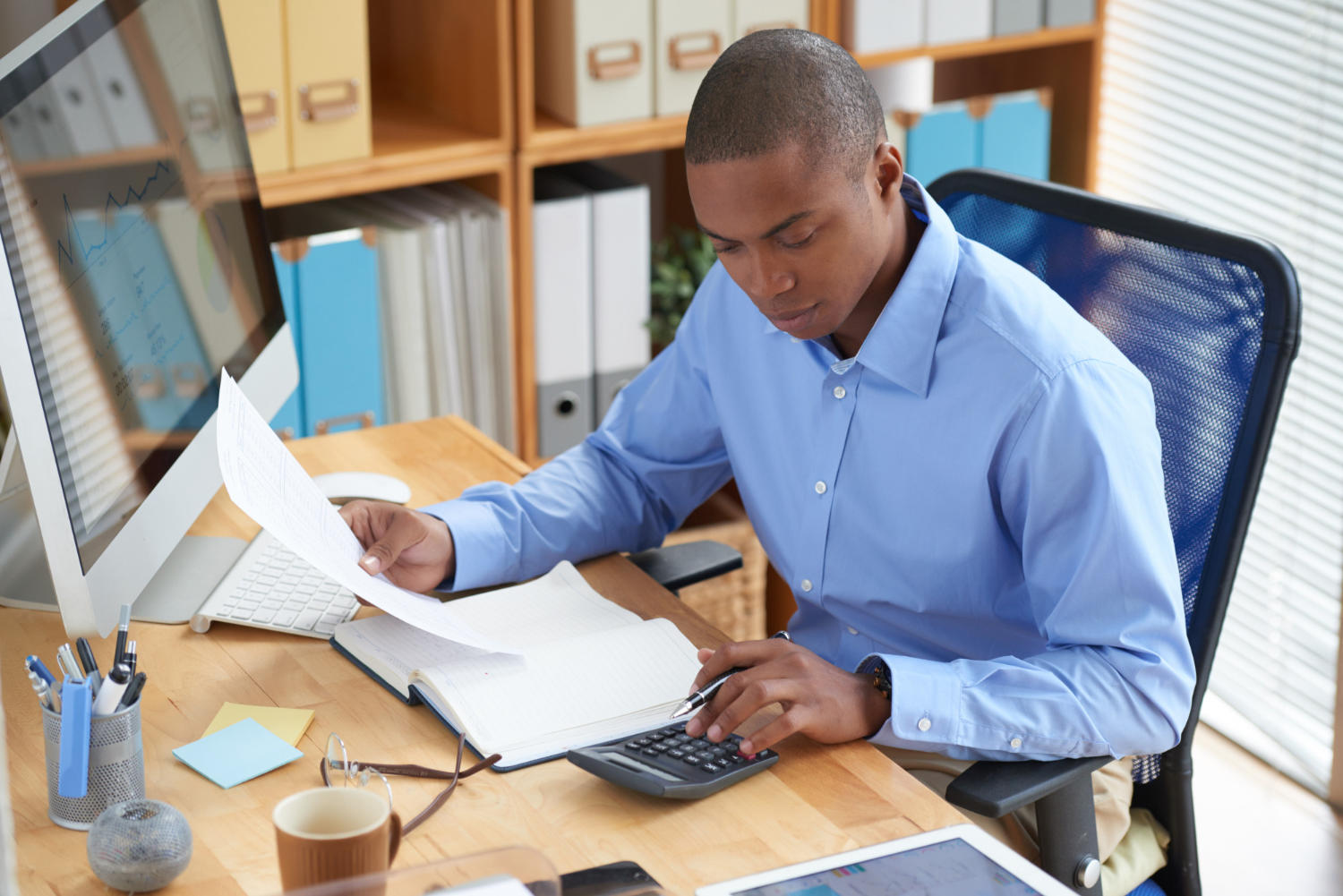 Contable frente a un PC analizando unos documentos