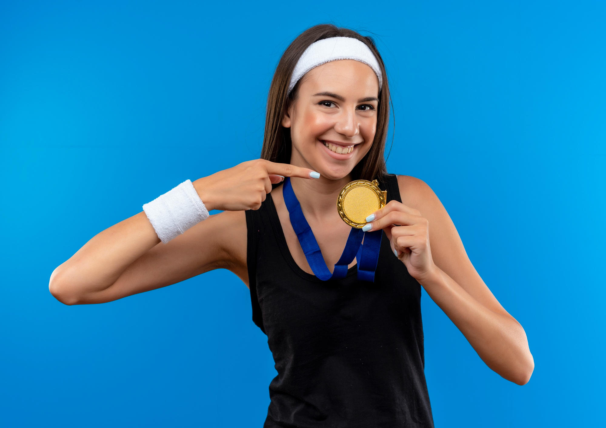 Chica sosteniendo y señalando una medalla