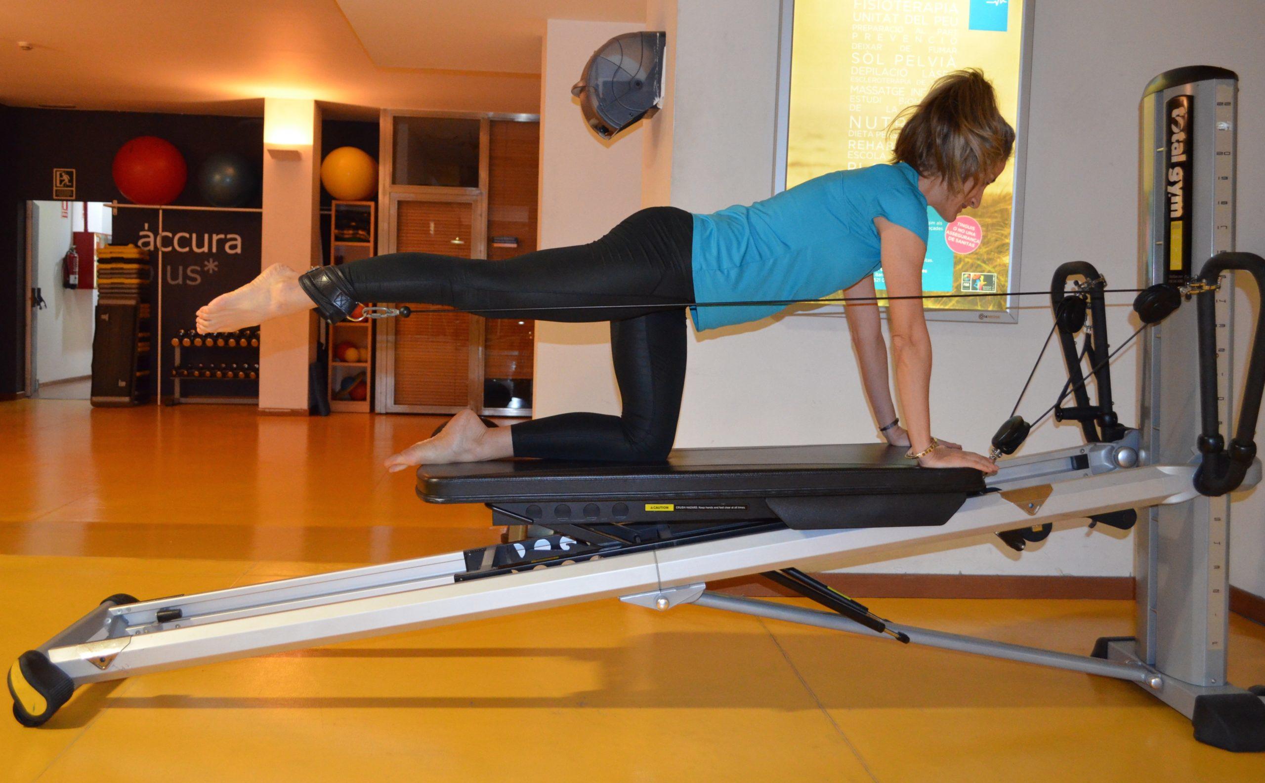 Chica haciendo pilates en un gimnasio.