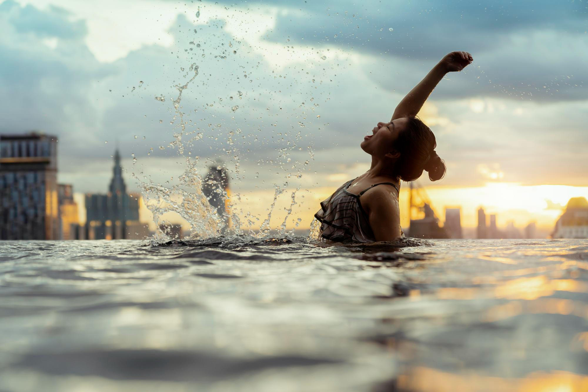 Silueta de mujer levantando el brazo en el agua