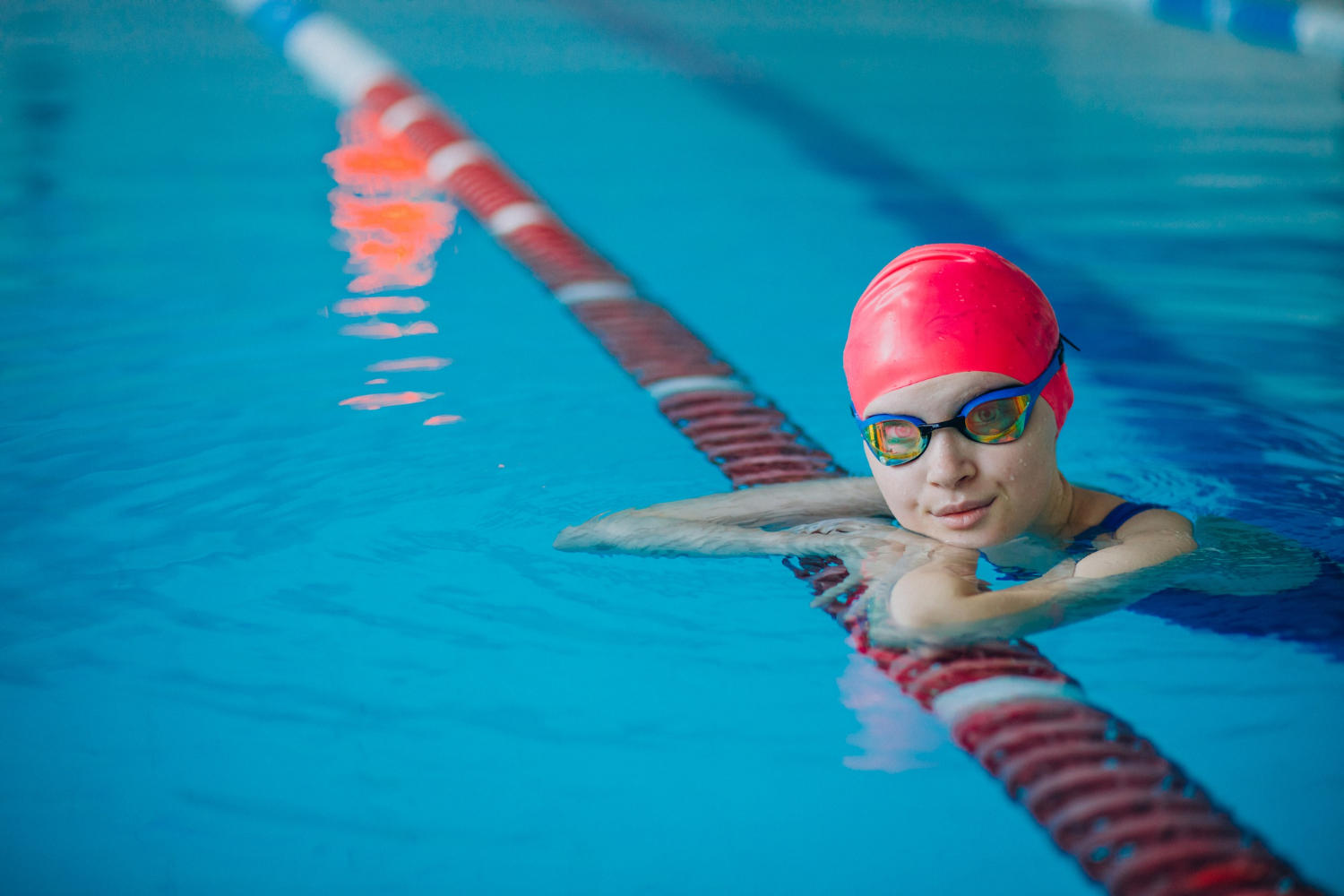 Niño en el borde de demarcador de carril de una piscina
