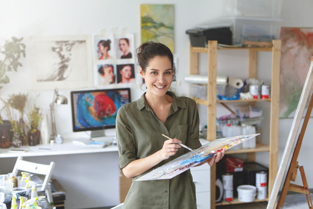 Mujer artista sosteniendo la paleta de colores en su taller
