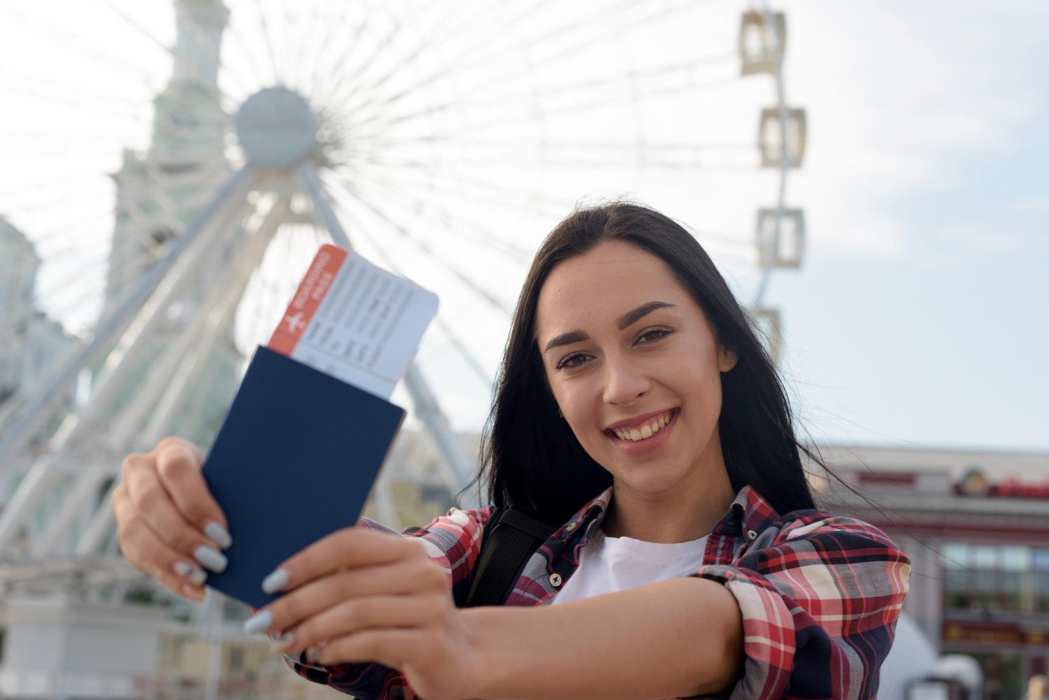 Chica sosteniendo pasaporte y tiquetes en la calle