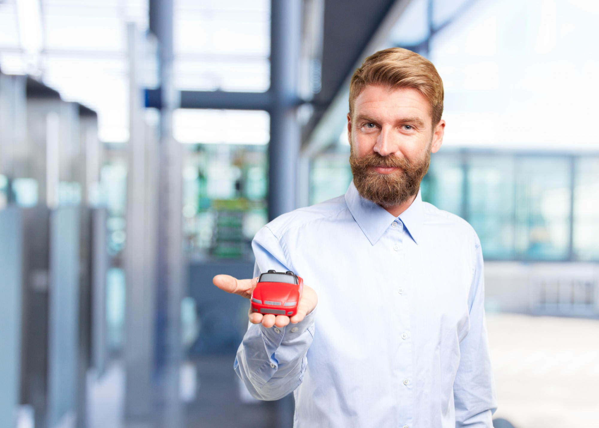 Hombre sosteniendo un modelo de automóvil en la mano