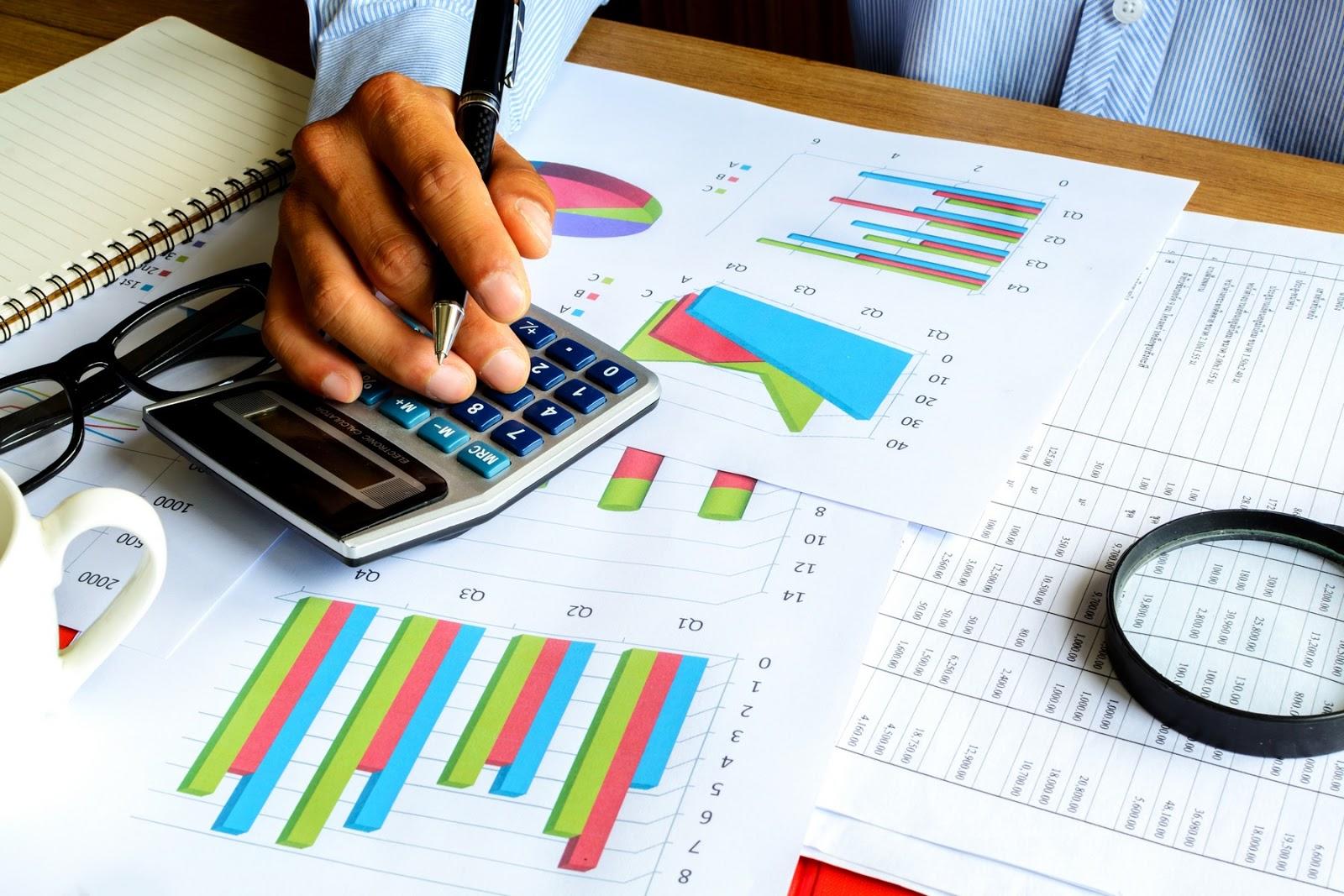 Profesor de matemáticas financieras, sosteniendo un esfero, mientras analiza informes.