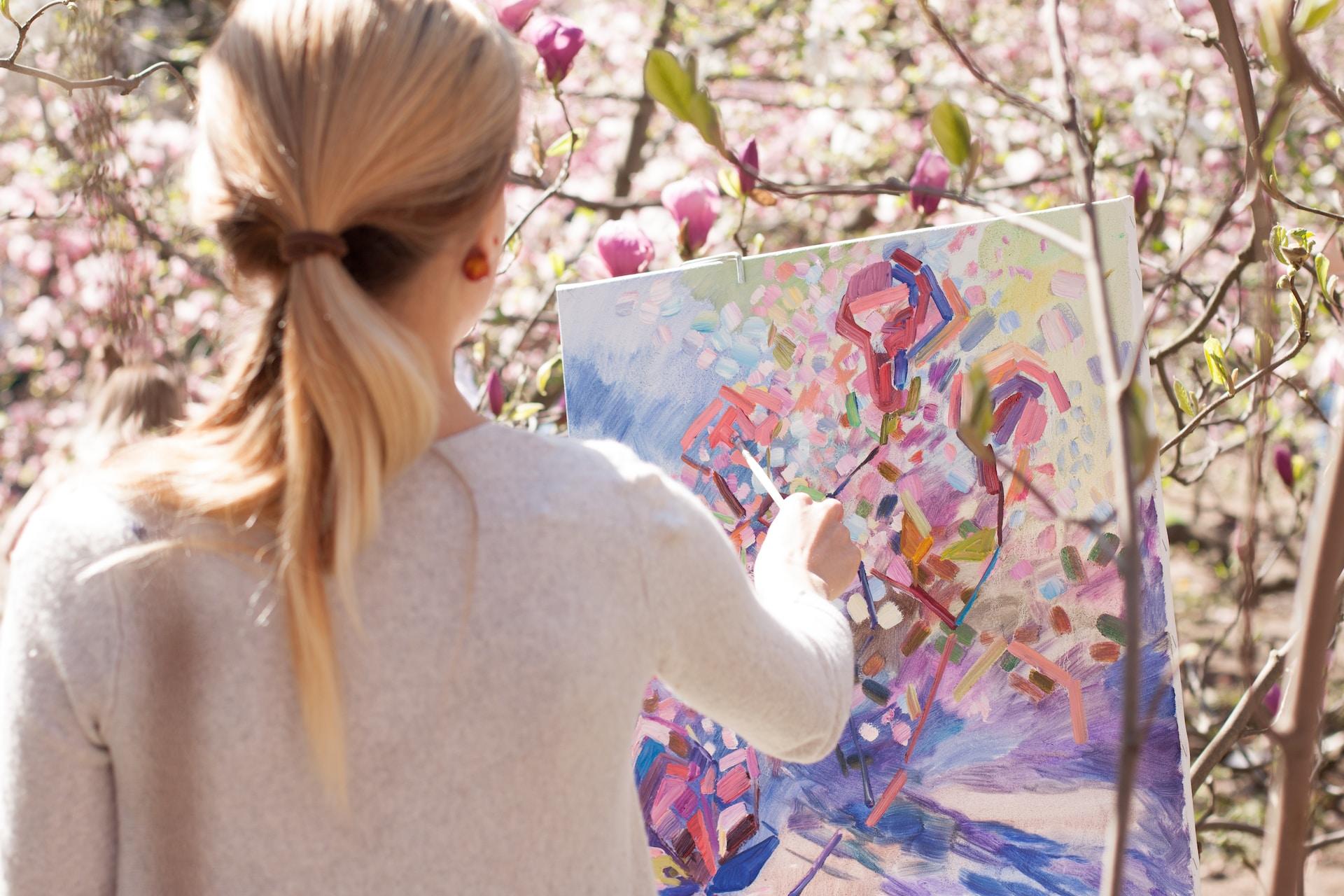 Chica pintando un hermoso cuadro de flores.