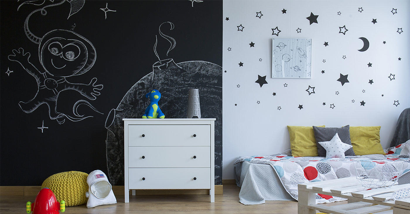 Espacio renovado con la tecnica de pintura de tiza, en el cual hay muebles y dibujos en al pared.