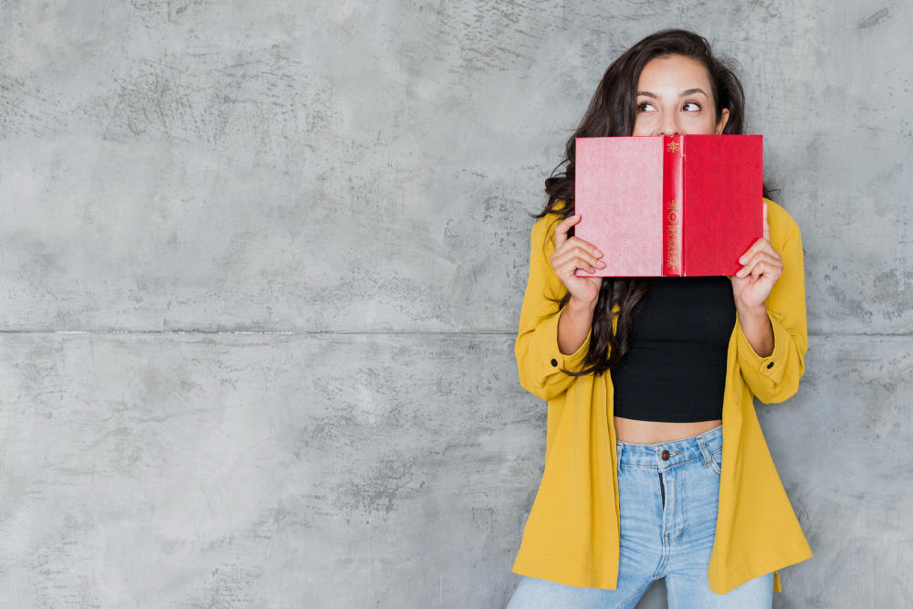 Mujer que tapa con un libro la parte de abajo de su cara