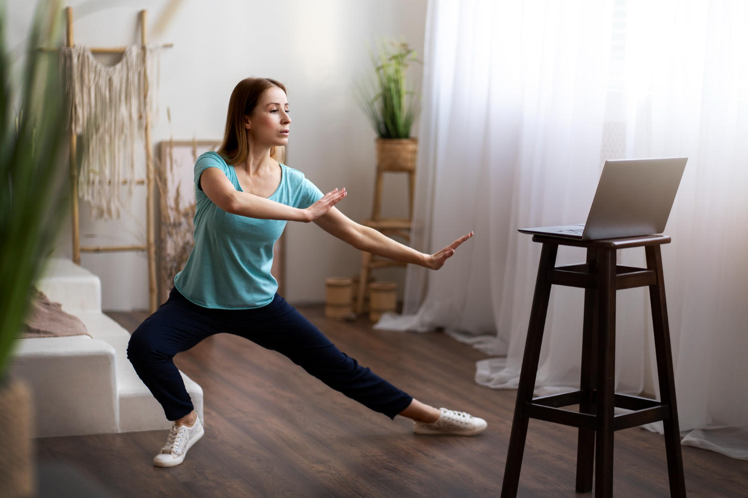 Mujer tomando clase online de baile, viendo a la pantalla