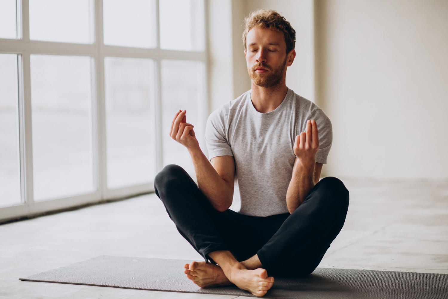 Hombre en posición de meditación juntando los dedos