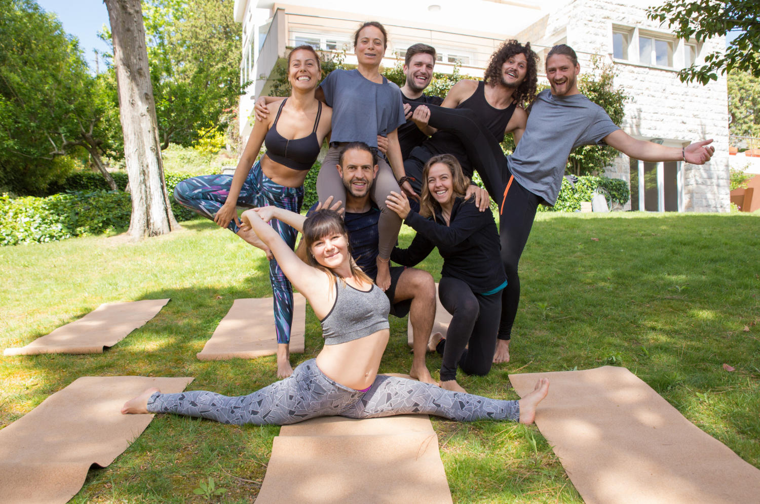 Grupo de 8 practicantes de yoga haciendo algún estiramiento